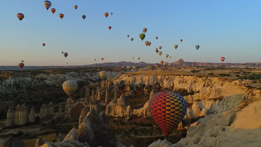 Hot air balloons flying over Cappadocia at sunrise